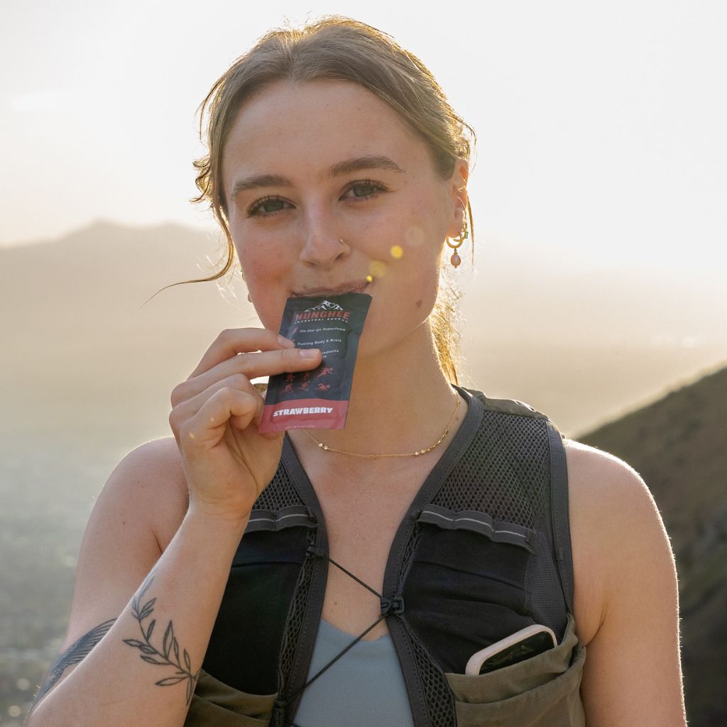 Female runner eating Hunghee Energy pack – animal-based fuel for trail running, ultras, and endurance athletes