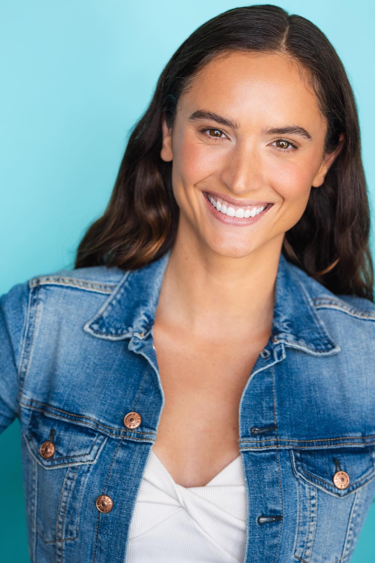 Krista Stewart, founder of Hunghee Energy, smiling in denim jacket – former elite gymnast and outdoor enthusiast from Utah