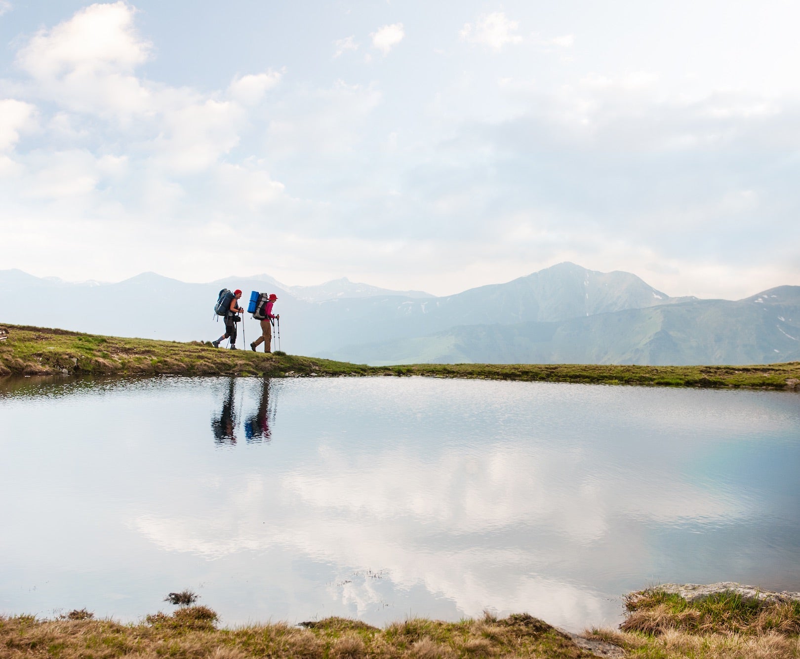 Two backpackers hiking by a mountain lake – symbolizing Hunghee Energy’s focus on clean ingredients and natural fuel for outdoor athletes