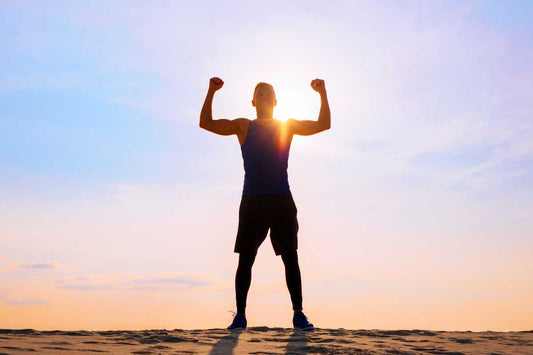 Runner silhouette celebrating at sunrise on a beach, motivation