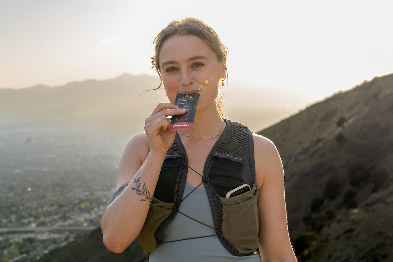 Trail runner refueling with Hunghee Energy strawberry pack at sunset – clean fuel for endurance and active lifestyles