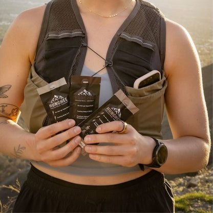 Hiker holding animal-based keto fuel packs with ghee and raw honey for long miles